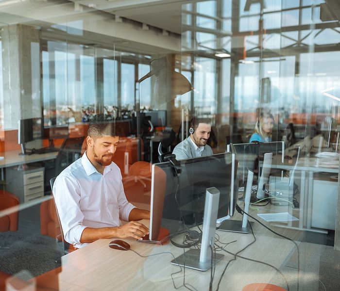 people on computers looking through window